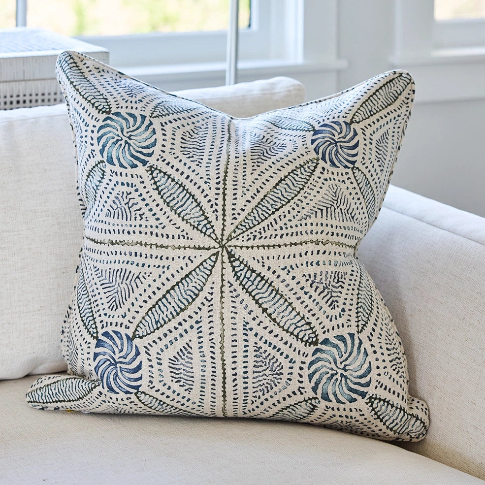 Decorative pillow with a geometric pattern on a beige sofa.