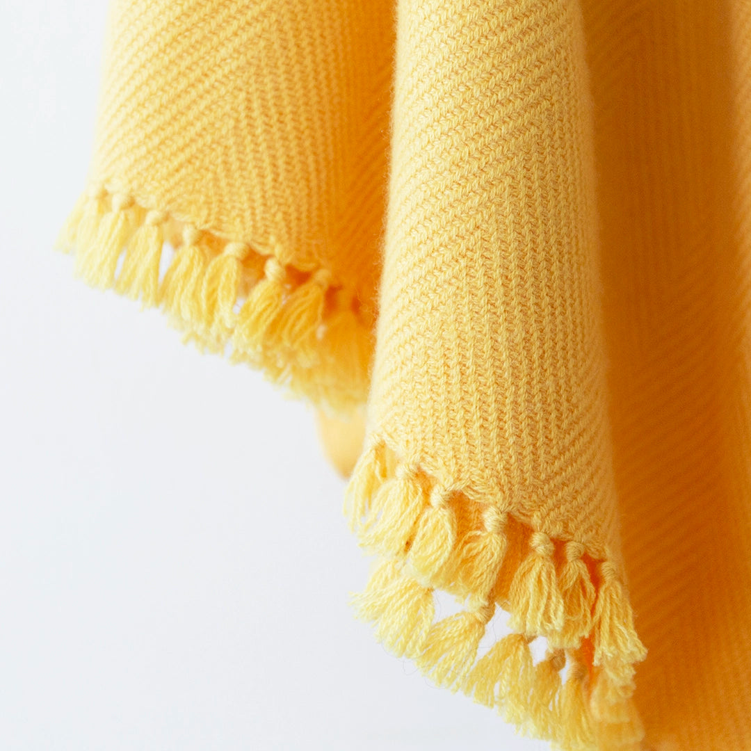 Close-up of a Nantucket Looms Sunflower Yellow cashmere throw blanket showing the soft weave and fringe.