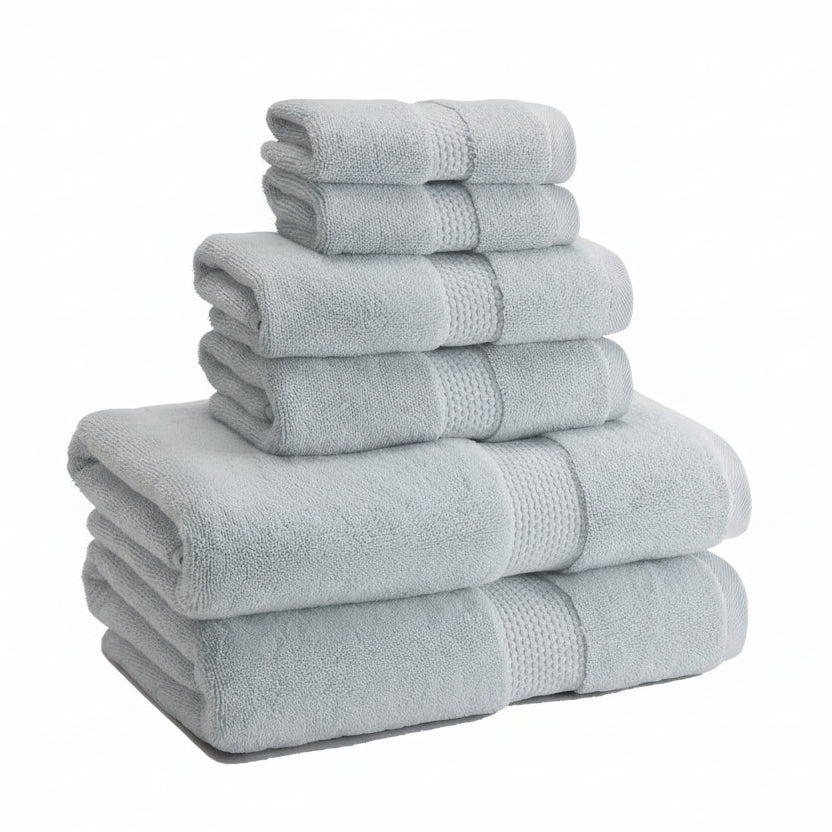 A stack of light blue Turkish cotton towels with detailed stitching, including a bath towel, hand towel, and washcloth.