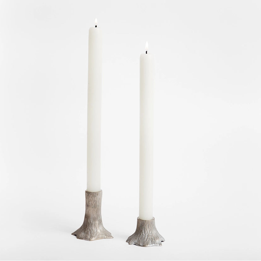 Two brass candle holders with a tarnished silver finish and a textured faux bois pattern, displayed against a white background.