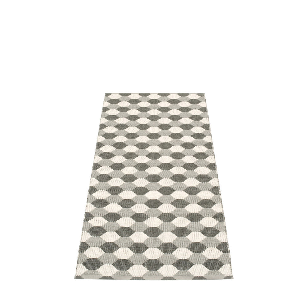 Long Pappelina rug featuring a monochrome geometric honeycomb pattern in shades of grey and white, set against a neutral backdrop.