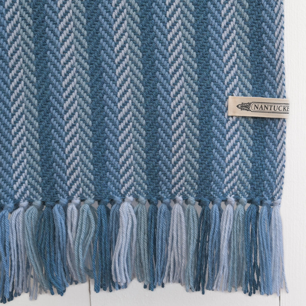 Close-up of Nantucket Looms' handwoven alpaca throw, emphasizing the luxurious texture and quality of the material with a branded label.