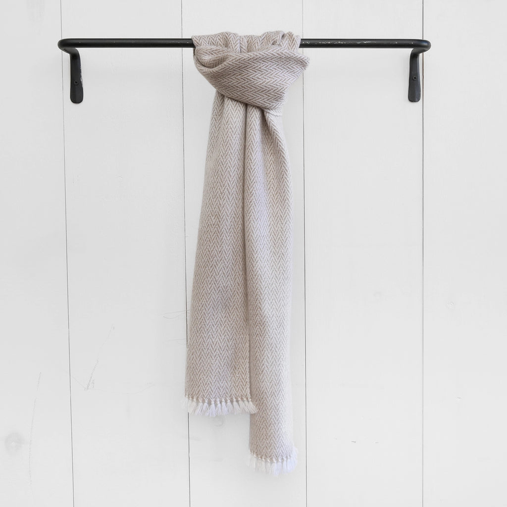 Sophisticated latte-colored cashmere scarf from Nantucket Looms, elegantly draped and revealing the plush weave and fringe on a neutral background.